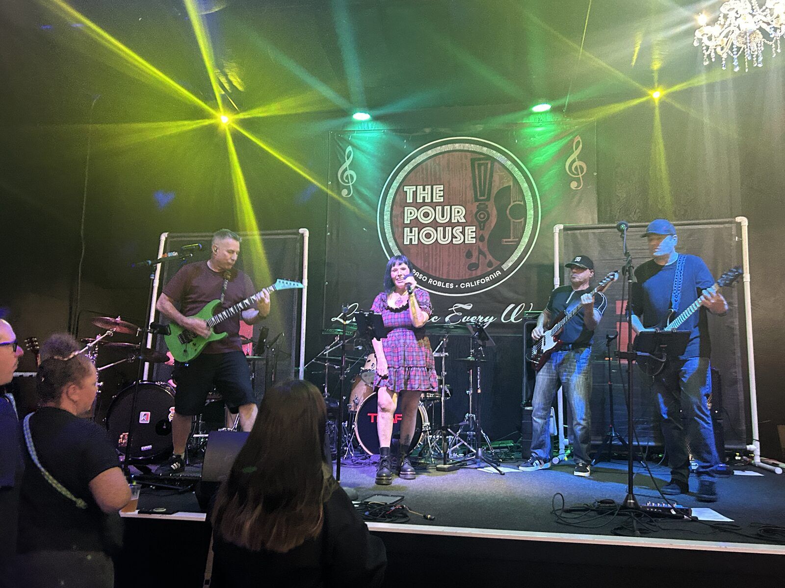 your alternative at the pour house in paso robles, september 23, 2026: a wide audience view of the band beneath stage lights, with the singer at the centre microphone.