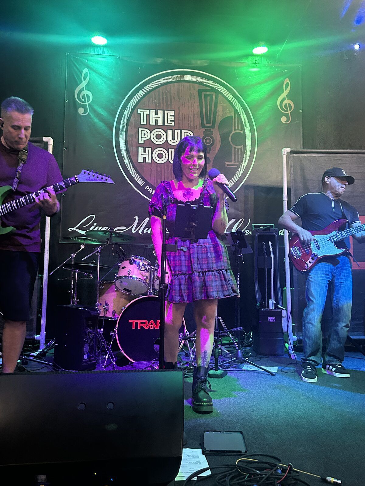 your alternative at the pour house in paso robles, september 23, 2026: the singer at the centre microphone with band members playing behind her.