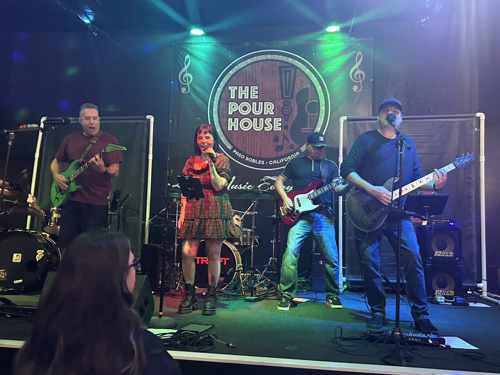 your alternative at the pour house in paso robles, september 23, 2026: the singer and three standing musicians across the stage, with the venue sign behind them.