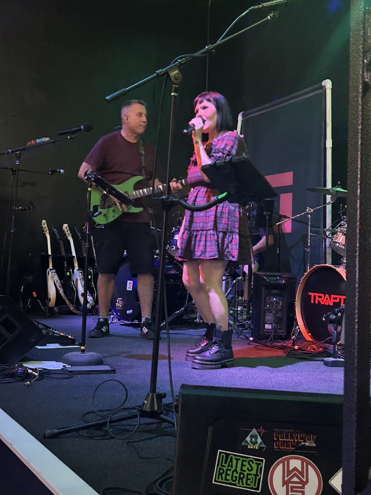 your alternative at the pour house in paso robles, september 23, 2026: the singer beside a guitarist, with microphones, amplifiers and the drum kit around them.