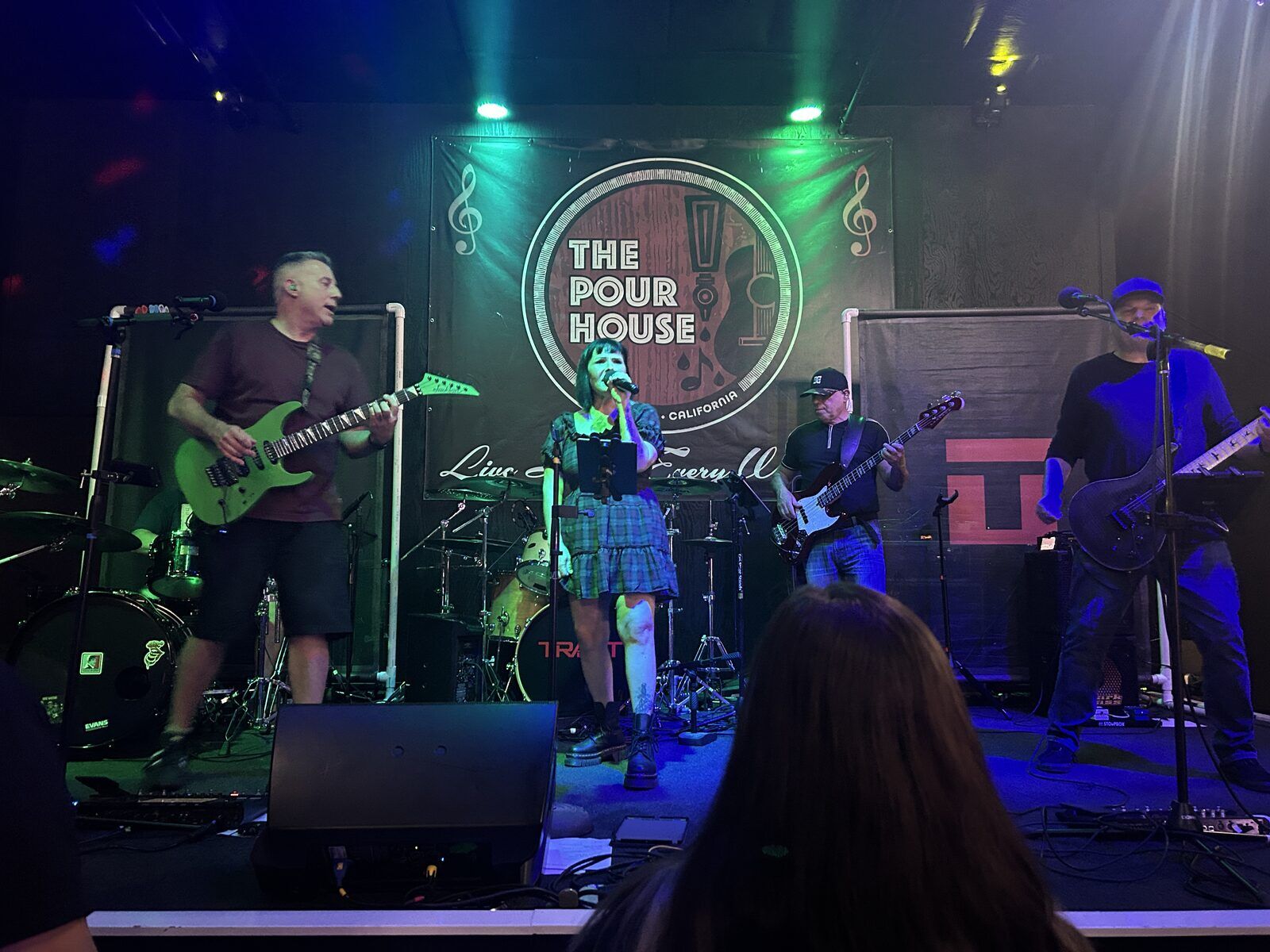 your alternative at the pour house in paso robles, september 23, 2026: a front-of-stage view of the singer, guitarists and bassist with audience silhouettes in front.